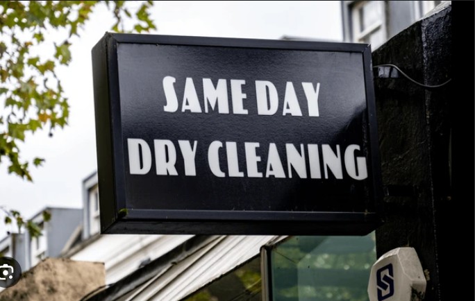 Professional dry cleaner pressing a suit jacket